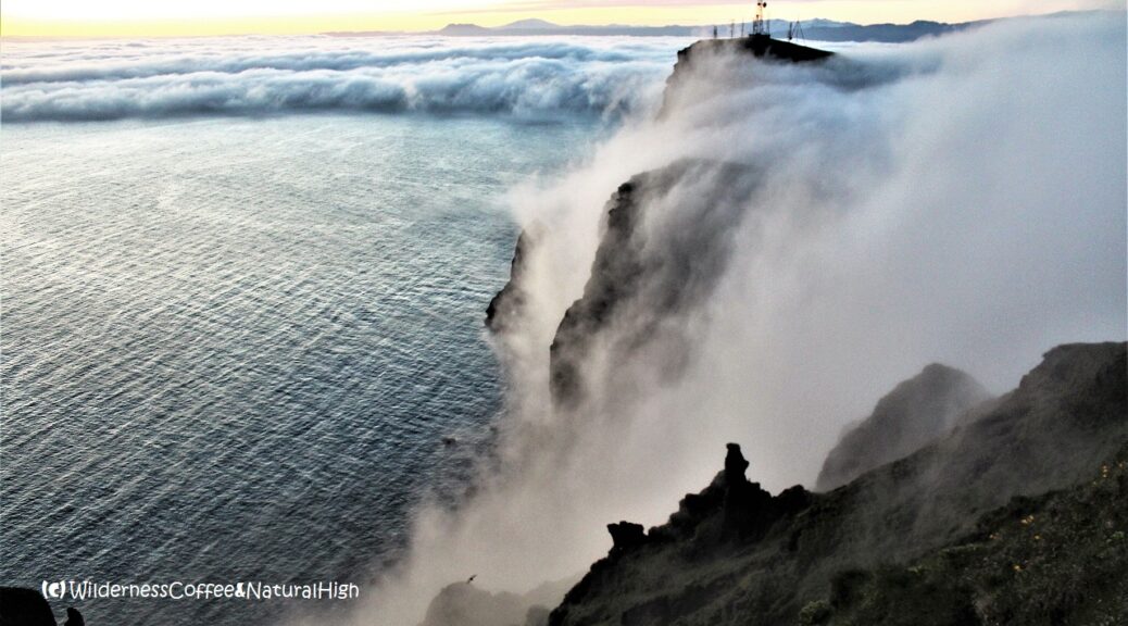 Fog waterfalls pouring over the cliffs, Heimaey, Vestmannaeyjar, Iceland.