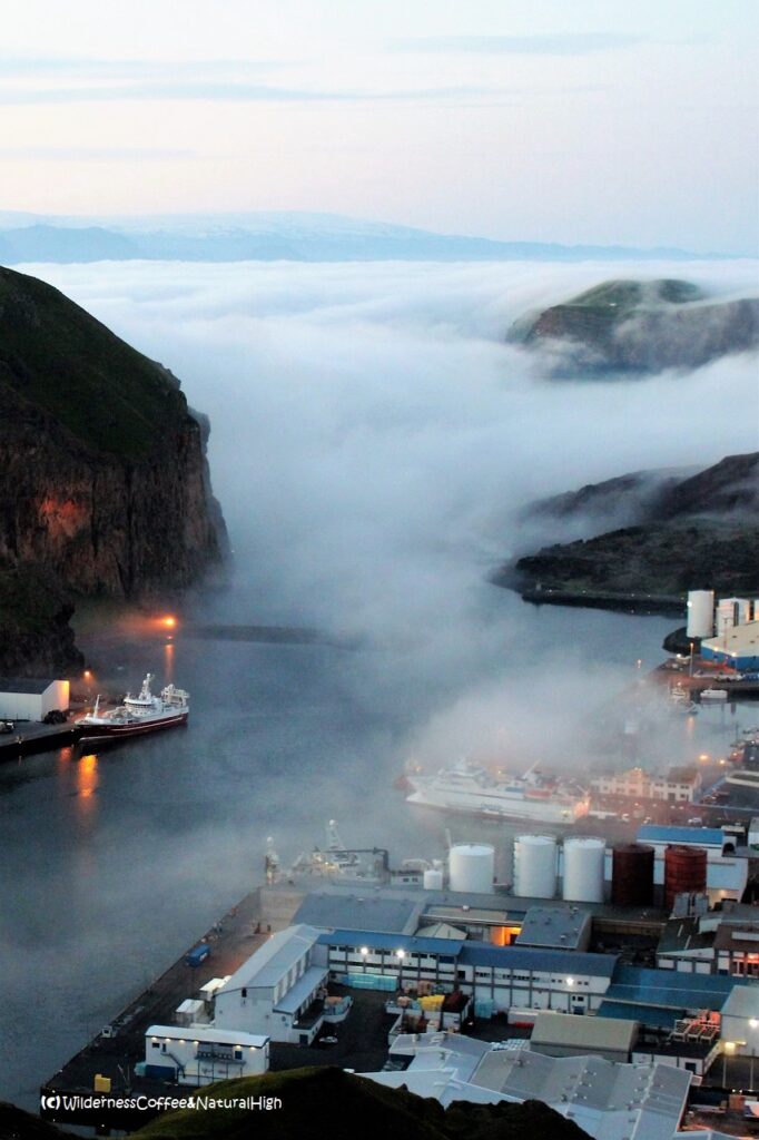 Fog waterfall gushing into Heimaey harbour Fog waterfall gushing into Heimaey harbour, Vestmannaeyjar, Iceland.