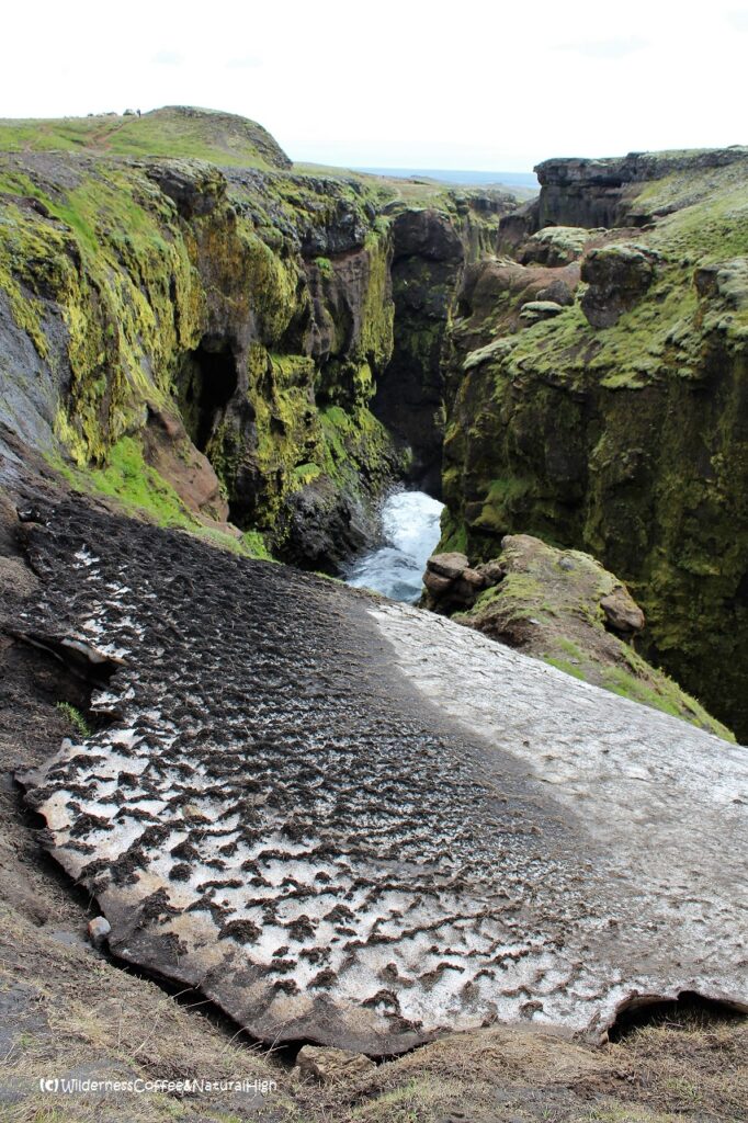 Ice sheet & canyon Skóga river gorge and ice sheet with Eyjafjallajökull ash, Iceland.